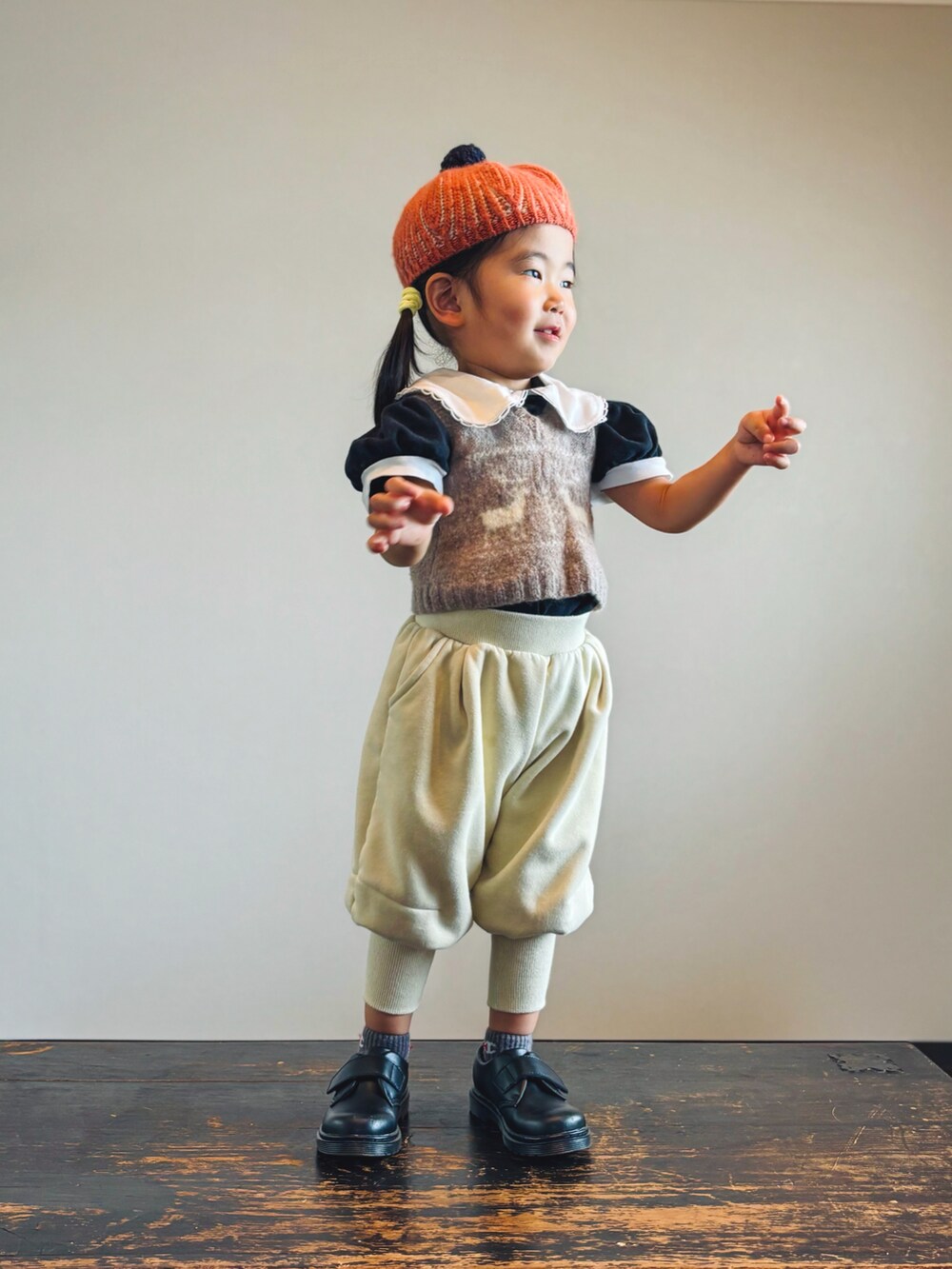 ベージュ系のベスト、ブラック系のTシャツ/カットソー、ベージュ系のパンツを着用したキッズの秋コーディネートの2枚目の写真