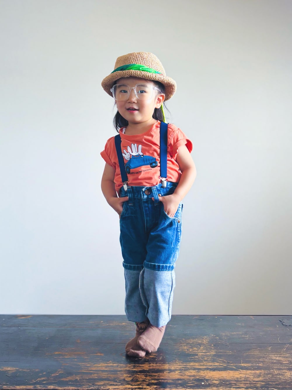 オレンジ系のTシャツ/カットソー、ブルー系のデニムパンツ、ホワイト系のメガネを着用したキッズの夏コーディネートの3枚目の写真