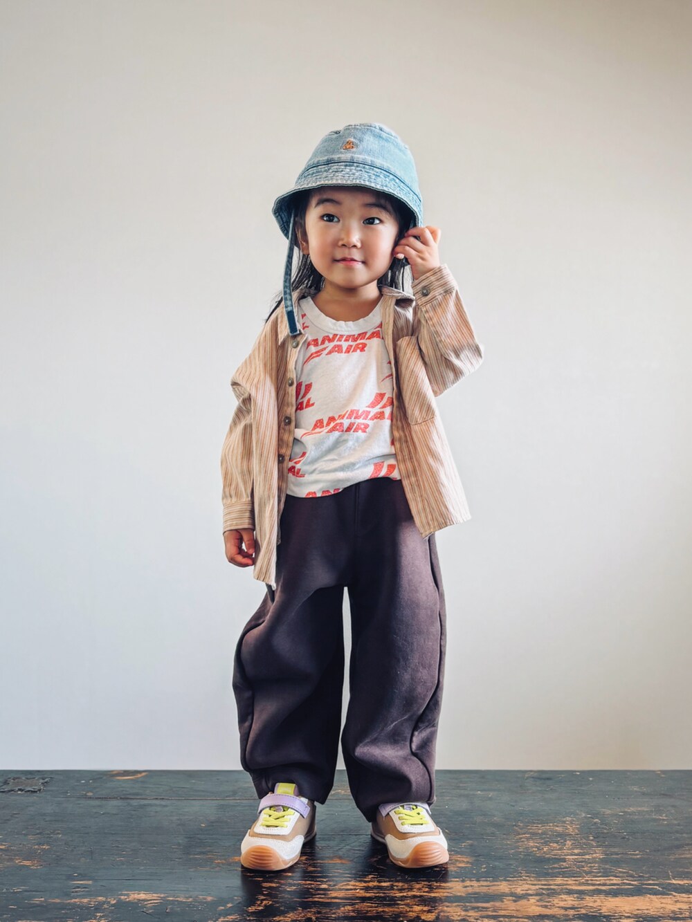 イエロー系のスニーカー、ホワイト系のタンクトップ、ベージュ系のシャツ/ブラウスを着用したキッズの秋コーディネートの3枚目の写真