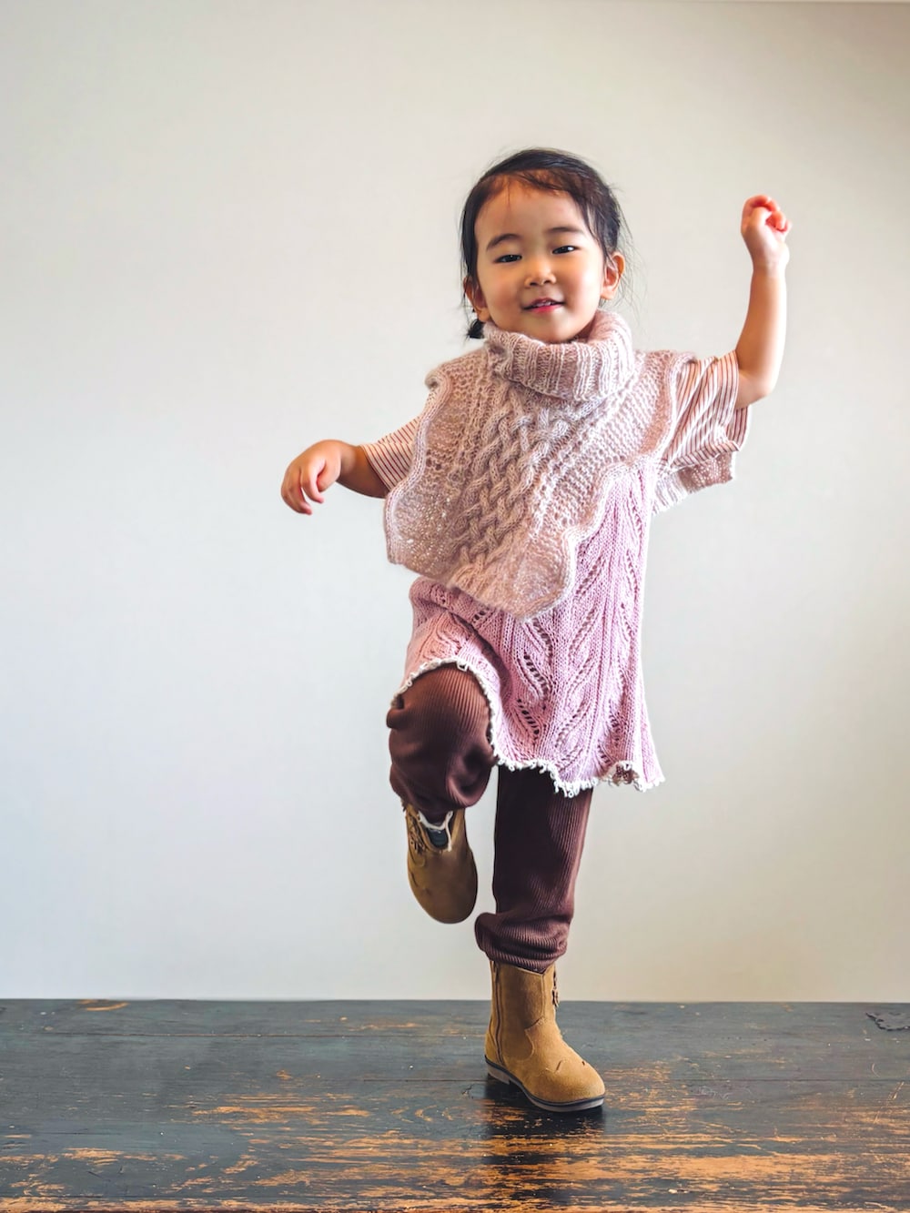 オレンジ系のTシャツ/カットソー、ブラウン系のパンツ、ピンク系のワンピースを着用したキッズの秋コーディネートの3枚目の写真