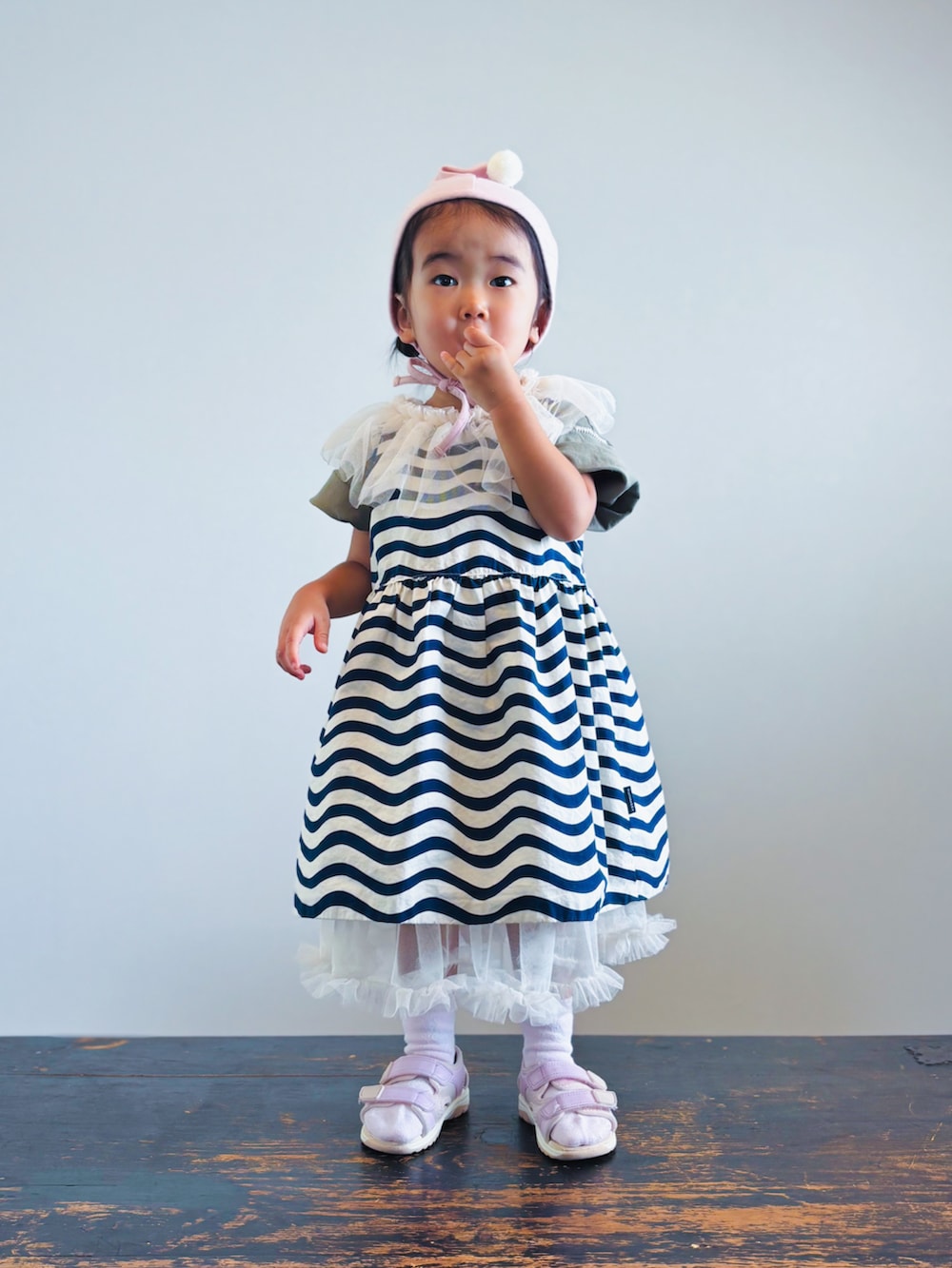 ホワイト系のワンピース、グリーン系のTシャツ/カットソー、ブラック系のワンピースを着用したキッズの秋コーディネートの3枚目の写真