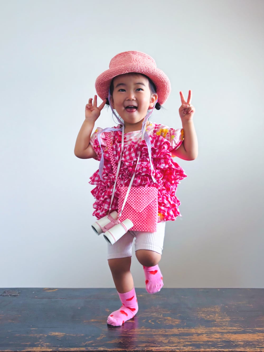 ピンク系のキャミソール、ピンク系のTシャツ/カットソー、ピンク系のハットを着用したキッズの夏コーディネートの5枚目の写真