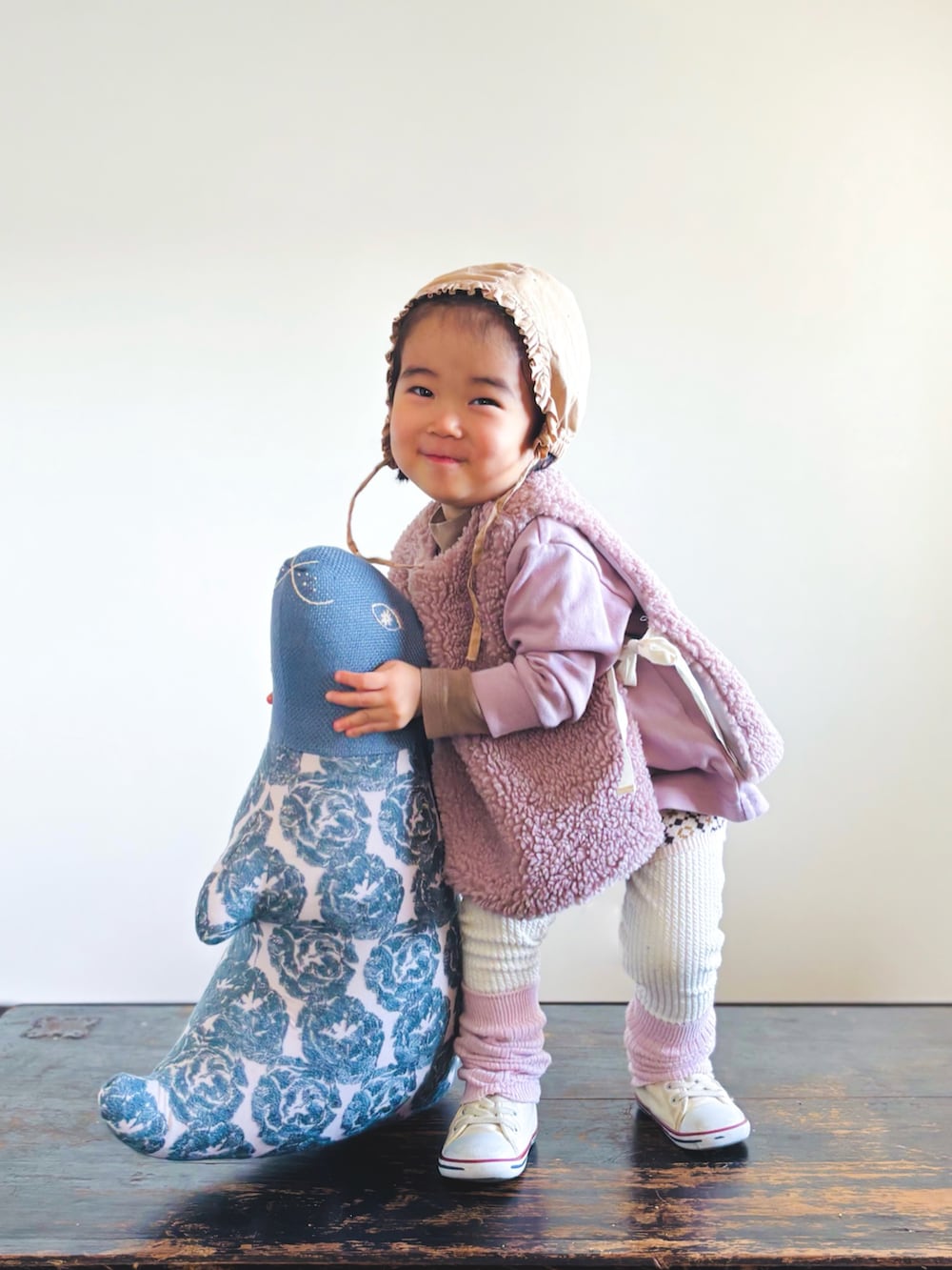 ホワイト系のスニーカー、ベージュ系のセットアップ、ピンク系のTシャツ/カットソーを着用したキッズの冬コーディネートの2枚目の写真