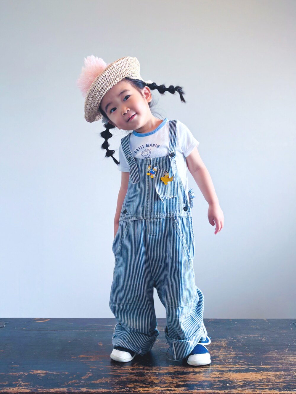 ブルー系のスニーカー、ホワイト系のTシャツ/カットソー、ブルー系のサロペット/オーバーオールを着用したキッズの夏コーディネートの3枚目の写真