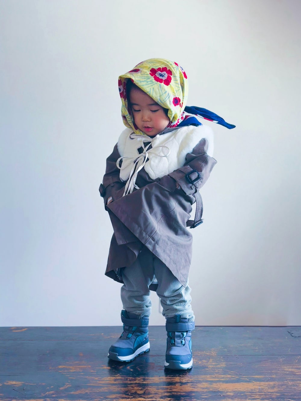 グリーン系のトレンチコート、グリーン系のその他パンツ、グレー系のブーツを着用したキッズの冬コーディネートの3枚目の写真