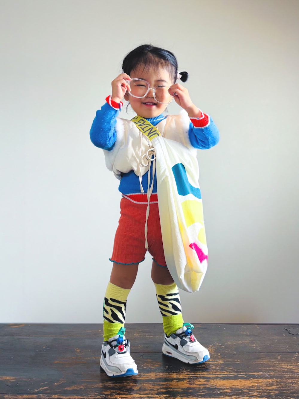 ホワイト系のスニーカー、オレンジ系のその他パンツ、ホワイト系のベストを着用したキッズの春コーディネートの3枚目の写真