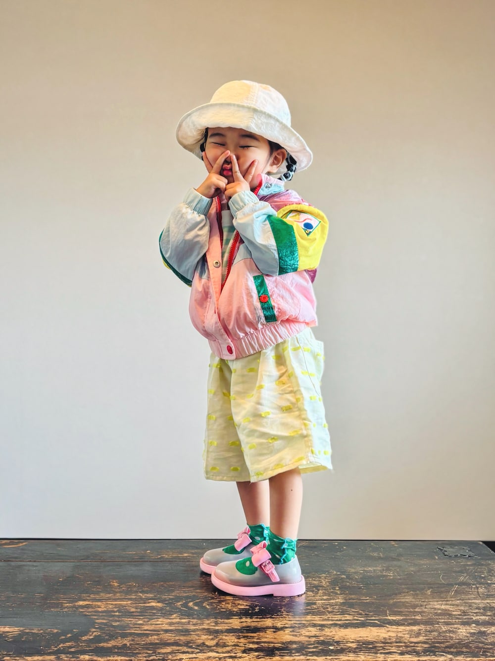 グリーン系のTシャツ/カットソー、ピンク系のセットアップ、イエロー系のパンツを着用したキッズの秋コーディネートの2枚目の写真