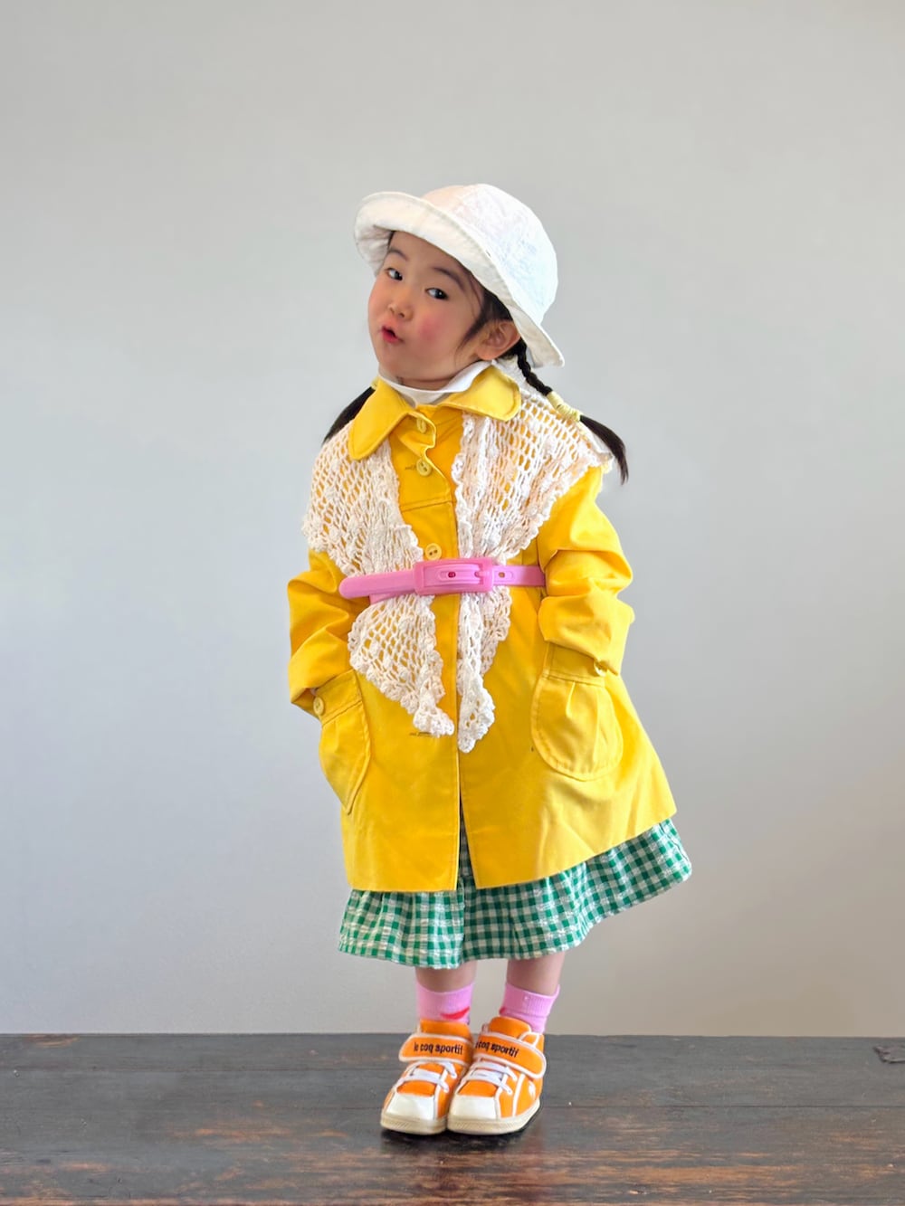 グリーン系のスカート、ホワイト系のTシャツ/カットソー、オレンジ系のスニーカーを着用したキッズの春コーディネートの2枚目の写真