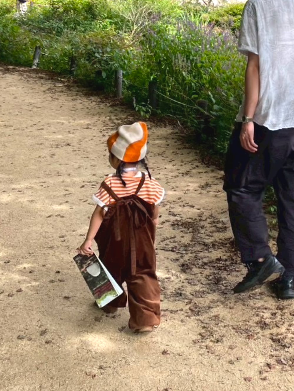 イエロー系のスニーカー、オレンジ系のTシャツ/カットソー、ブラウン系のサロペット/オーバーオールを着用したキッズの秋コーディネートの3枚目の写真