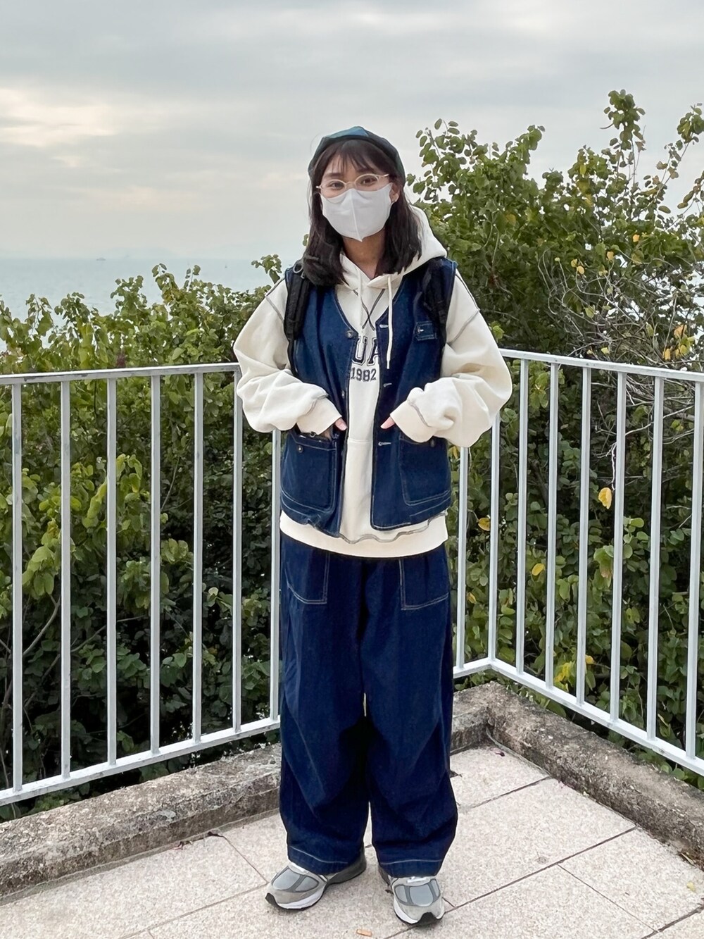 ブルー系のデニムジャケット、グレー系のスニーカー、ブラック系のバックパック/リュックを着用したレディースの冬コーディネートの3枚目の写真