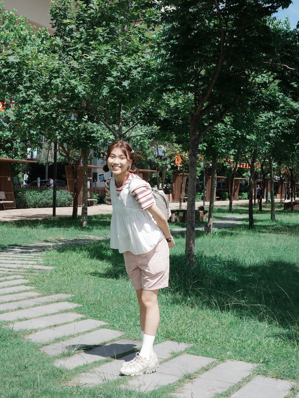 ベージュ系のスニーカー、ピンク系のパンツ、グレー系のバッグを着用したレディースの秋コーディネートの2枚目の写真