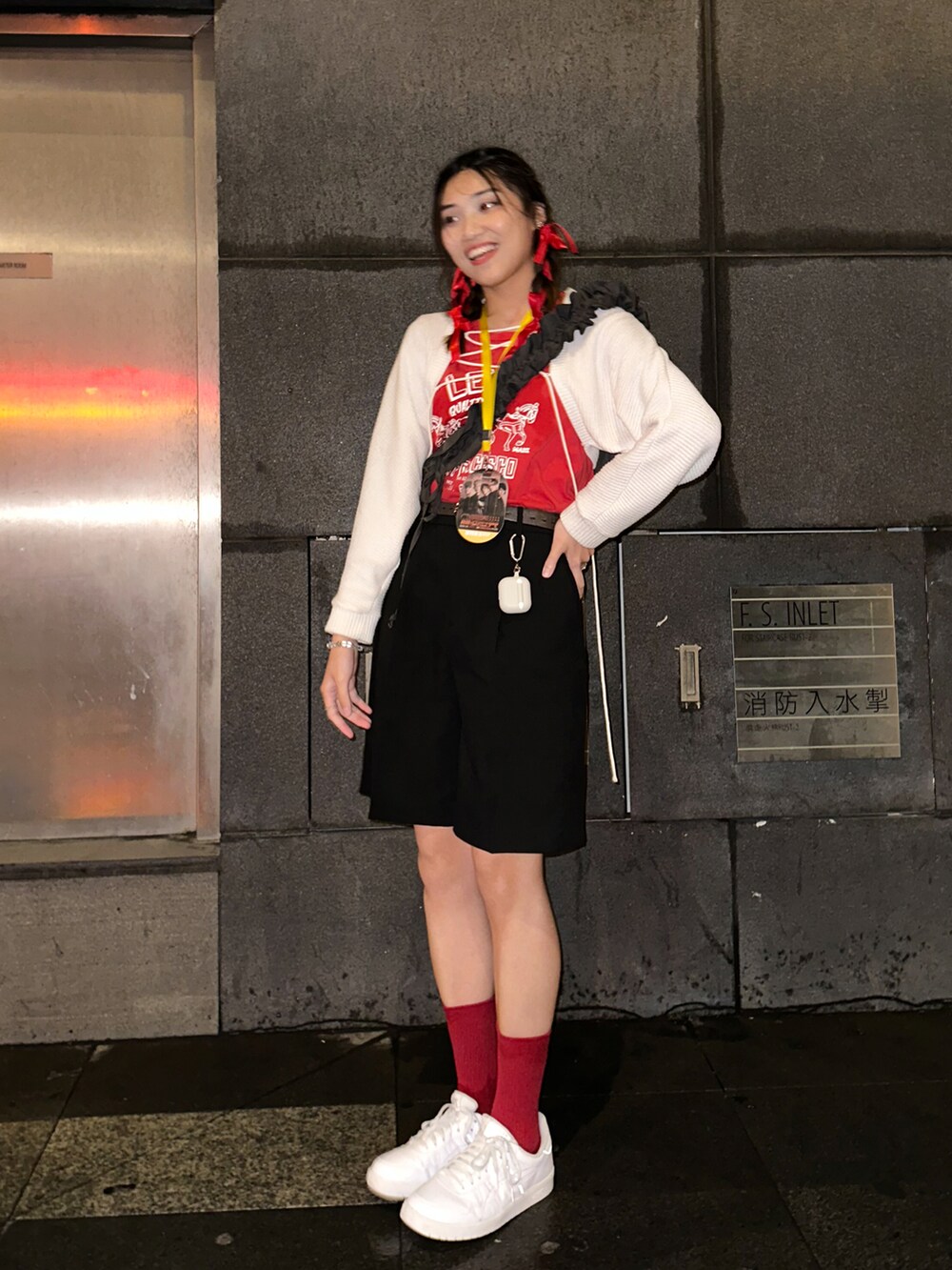 ホワイト系のスニーカー、レッド系のTシャツ/カットソー、ブラック系のその他パンツを着用したレディースの春コーディネートの3枚目の写真