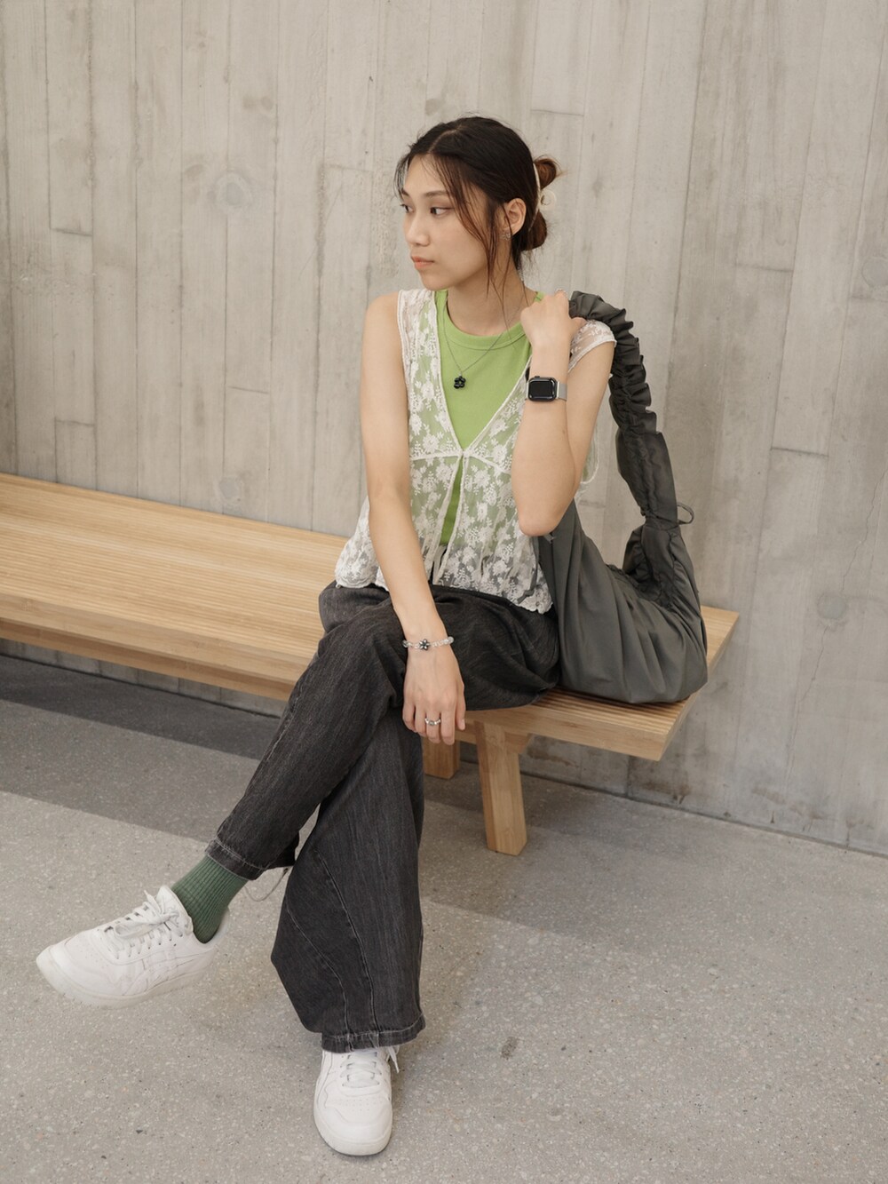 グリーン系のトップス、ホワイト系のスニーカー、ブラック系のサングラスを着用したレディースの夏コーディネートの3枚目の写真