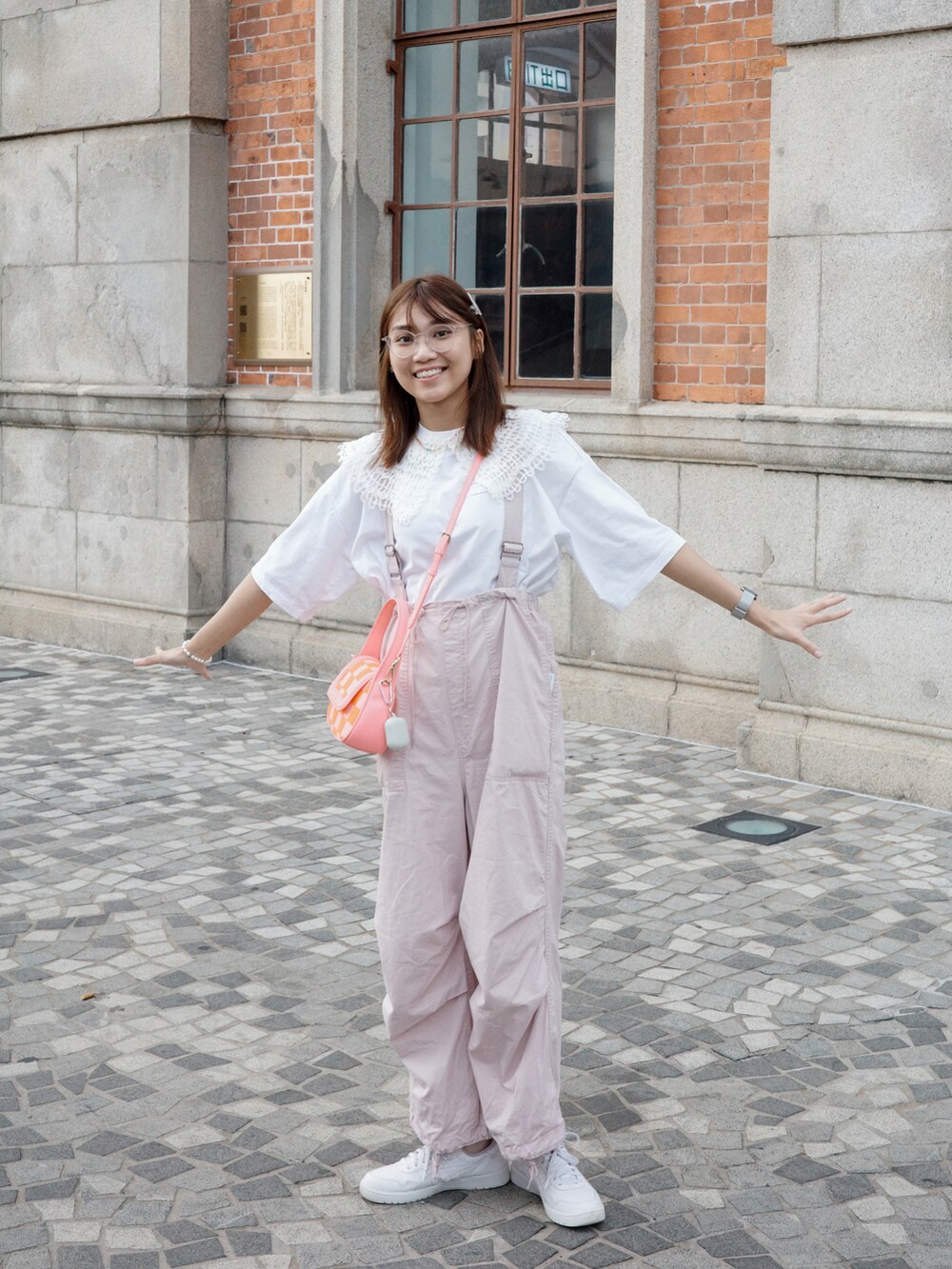 ピンク系のサロペット/オーバーオール、ホワイト系のスニーカー、ピンク系のショルダーバッグを着用したレディースの夏コーディネートの3枚目の写真
