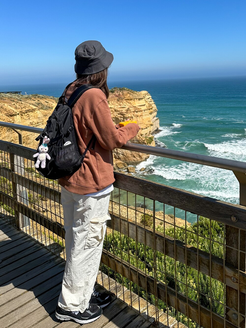 ブラウン系のトップス、ブラック系のスニーカー、ブラック系のハットを着用したレディースの冬コーディネートの2枚目の写真