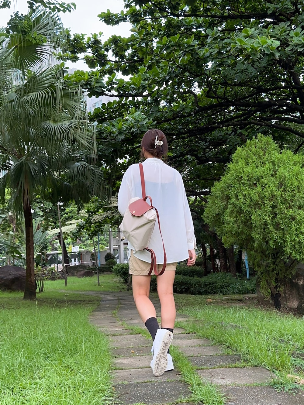 ブラック系のトップス、ホワイト系のトップス、ベージュ系のバックパック/リュックを着用したレディースの夏コーディネートの2枚目の写真