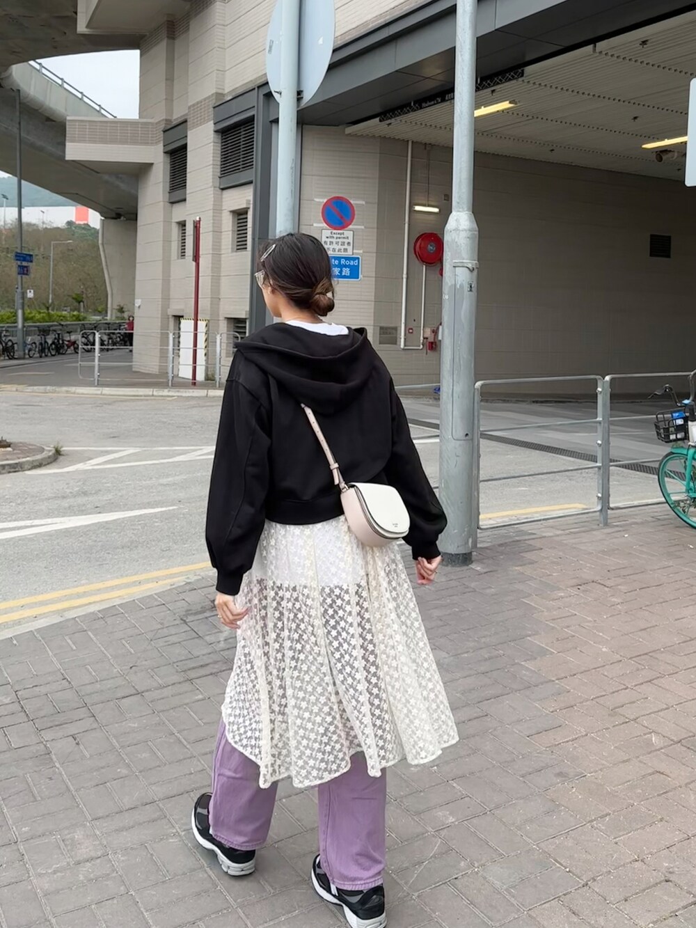 ブラック系のパーカー、パープル系のパンツ、ブラック系のスニーカーを着用したレディースの夏コーディネートの2枚目の写真