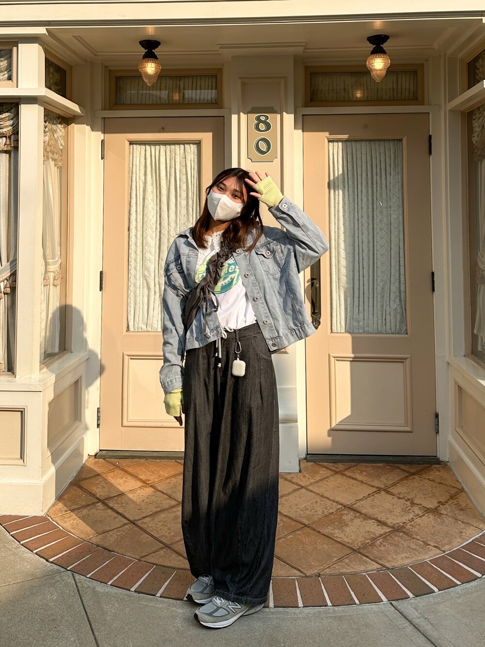 ホワイト系のTシャツ/カットソー、ブルー系のデニムジャケット、グレー系のスニーカーを着用したレディースの冬コーディネートの3枚目の写真