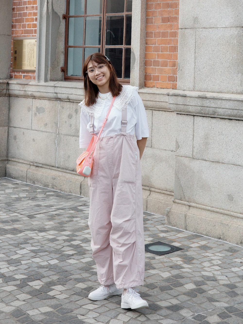 ピンク系のサロペット/オーバーオール、ホワイト系のスニーカー、ピンク系のショルダーバッグを着用したレディースの夏コーディネートの2枚目の写真