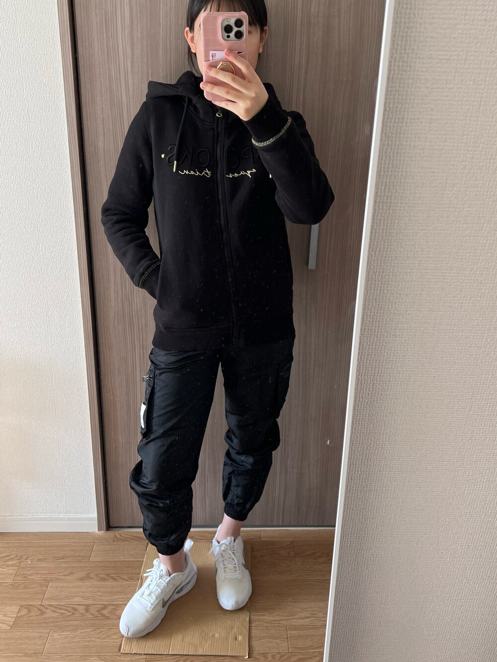 ブラック系のTシャツ/カットソー、ブラック系のその他パンツ、ホワイト系のスニーカーを着用したレディースの冬コーディネートの2枚目の写真