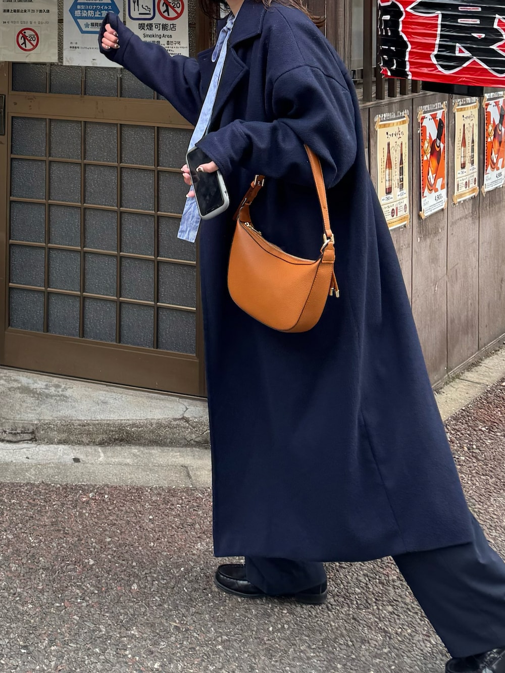 ブルー系のスウェット、ブラウン系のバッグ、ブルー系のパンツを着用したレディースの春コーディネートの2枚目の写真