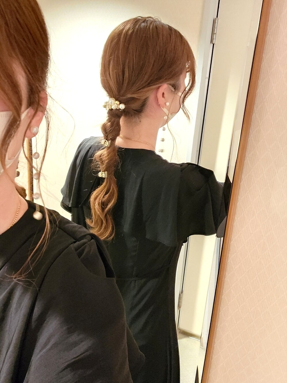 ブラック系のワンピース、ベージュ系のハンドバッグ、ゴールド系のパンプスを着用したレディースの夏コーディネートの3枚目の写真