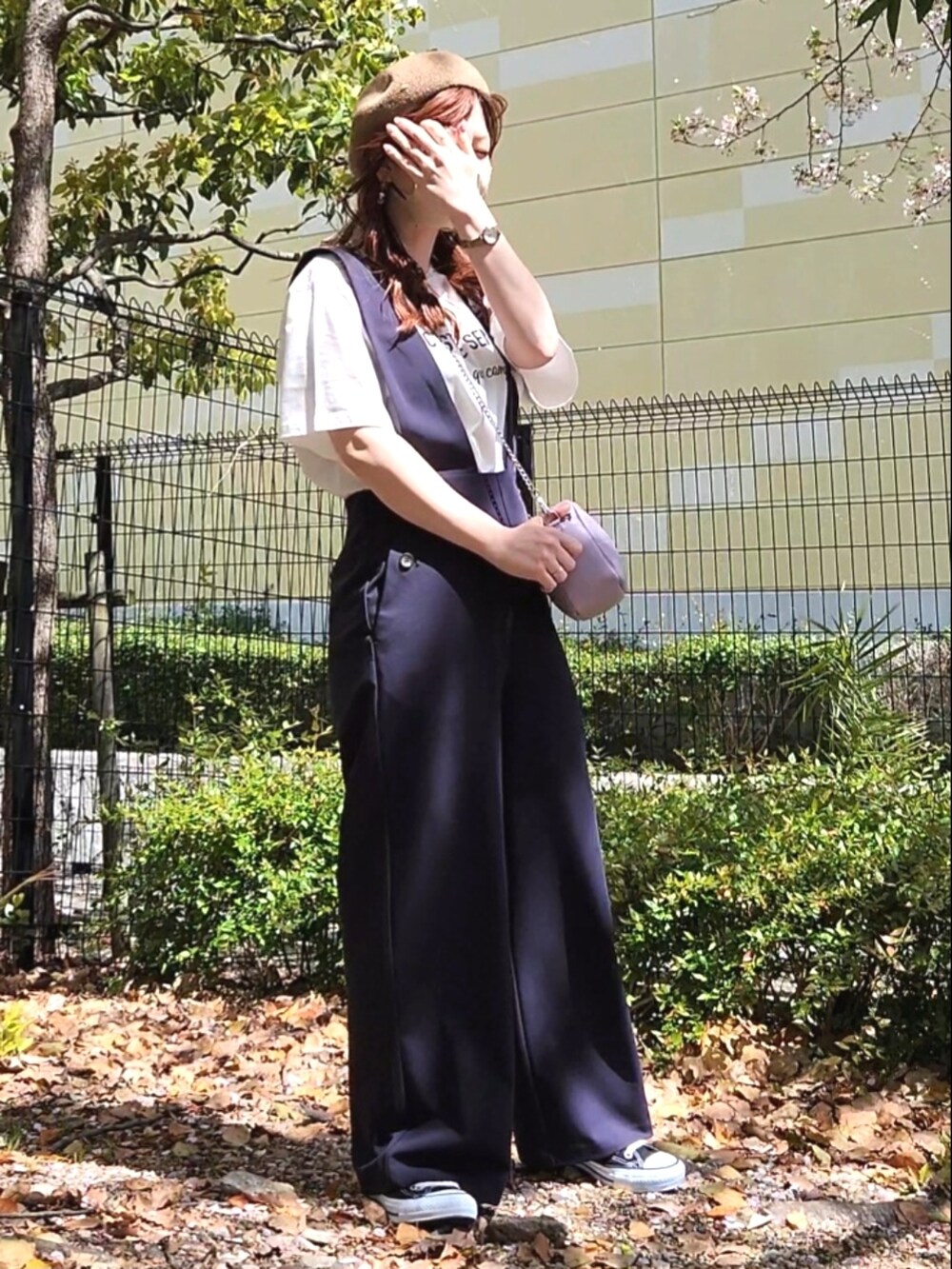 ブラック系のスニーカー、ブルー系のサロペット/オーバーオール、ホワイト系のTシャツ/カットソーを着用したレディースの春コーディネートの2枚目の写真