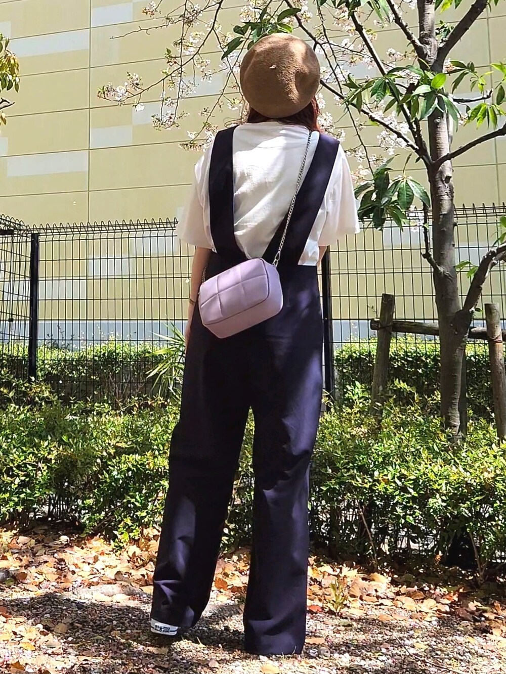 ブラック系のスニーカー、ブルー系のサロペット/オーバーオール、ホワイト系のTシャツ/カットソーを着用したレディースの春コーディネートの4枚目の写真