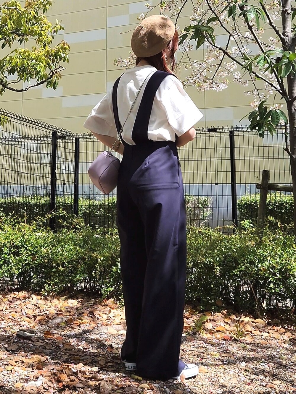 ブラック系のスニーカー、ブルー系のサロペット/オーバーオール、ホワイト系のTシャツ/カットソーを着用したレディースの春コーディネートの3枚目の写真