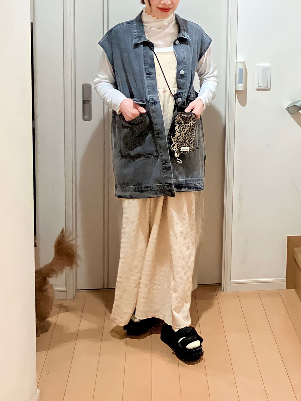 ブラック系のデニムジャケット、ベージュ系のワンピース、ブラック系のサンダルを着用したレディースの春コーディネートの2枚目の写真