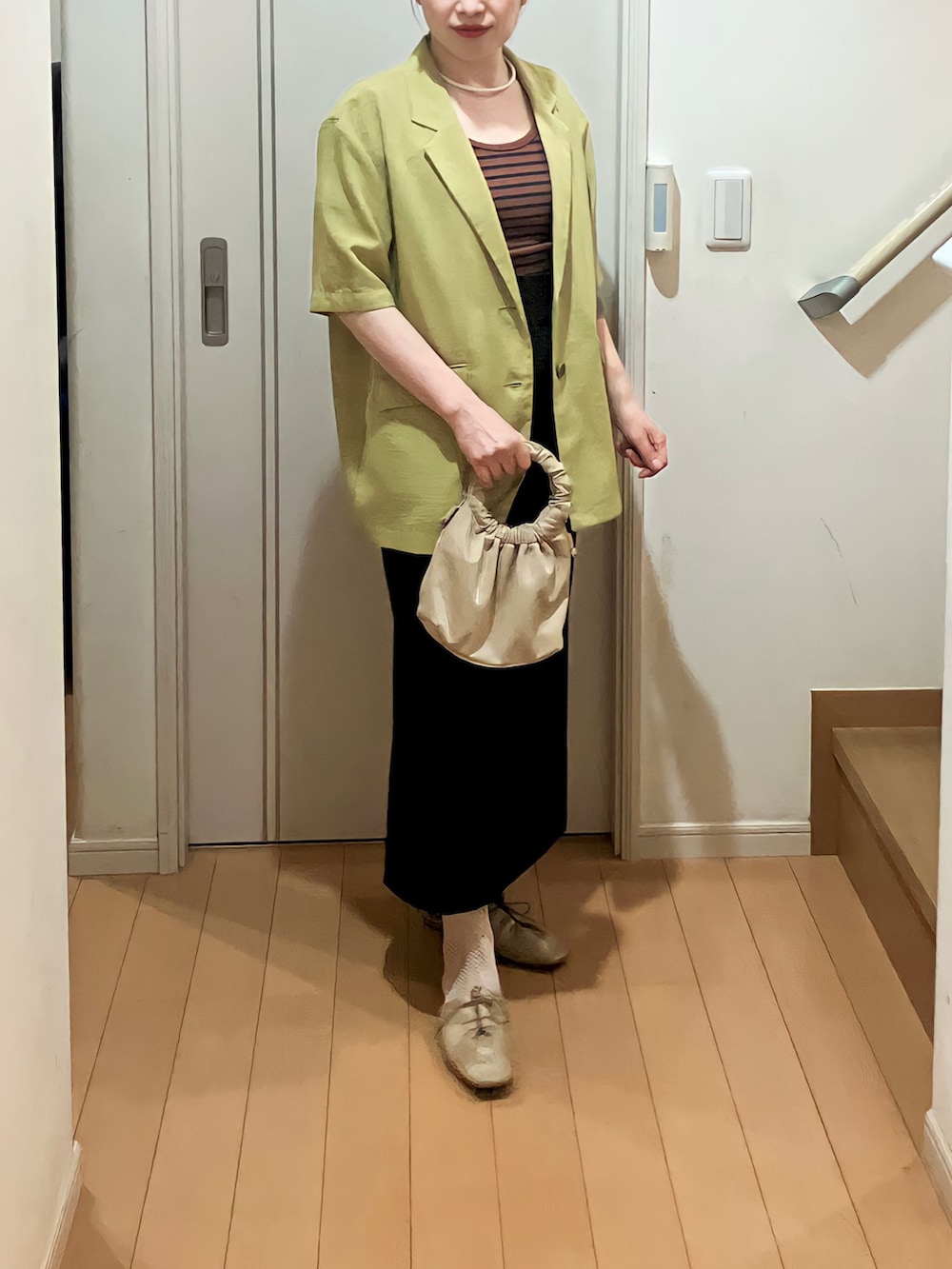 グリーン系のテーラードジャケット、ブラウン系のTシャツ/カットソー、ベージュ系のショルダーバッグを着用したレディースの春コーディネートの4枚目の写真