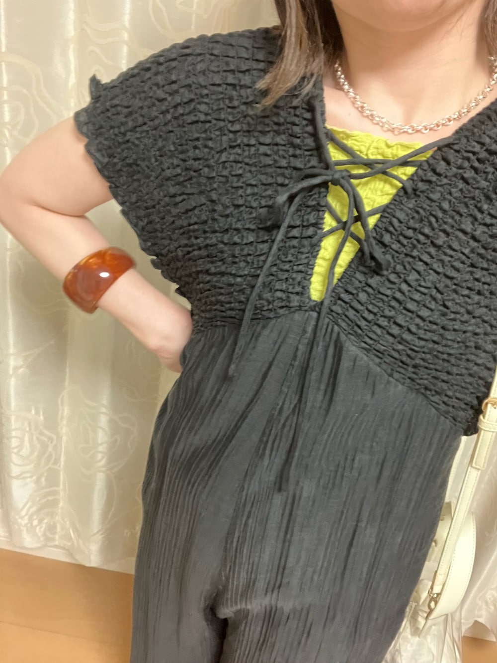 ブラック系のつなぎ/オールインワン、イエロー系のタンクトップ、ブラウン系のブレスレットを着用したレディースの夏コーディネートの2枚目の写真