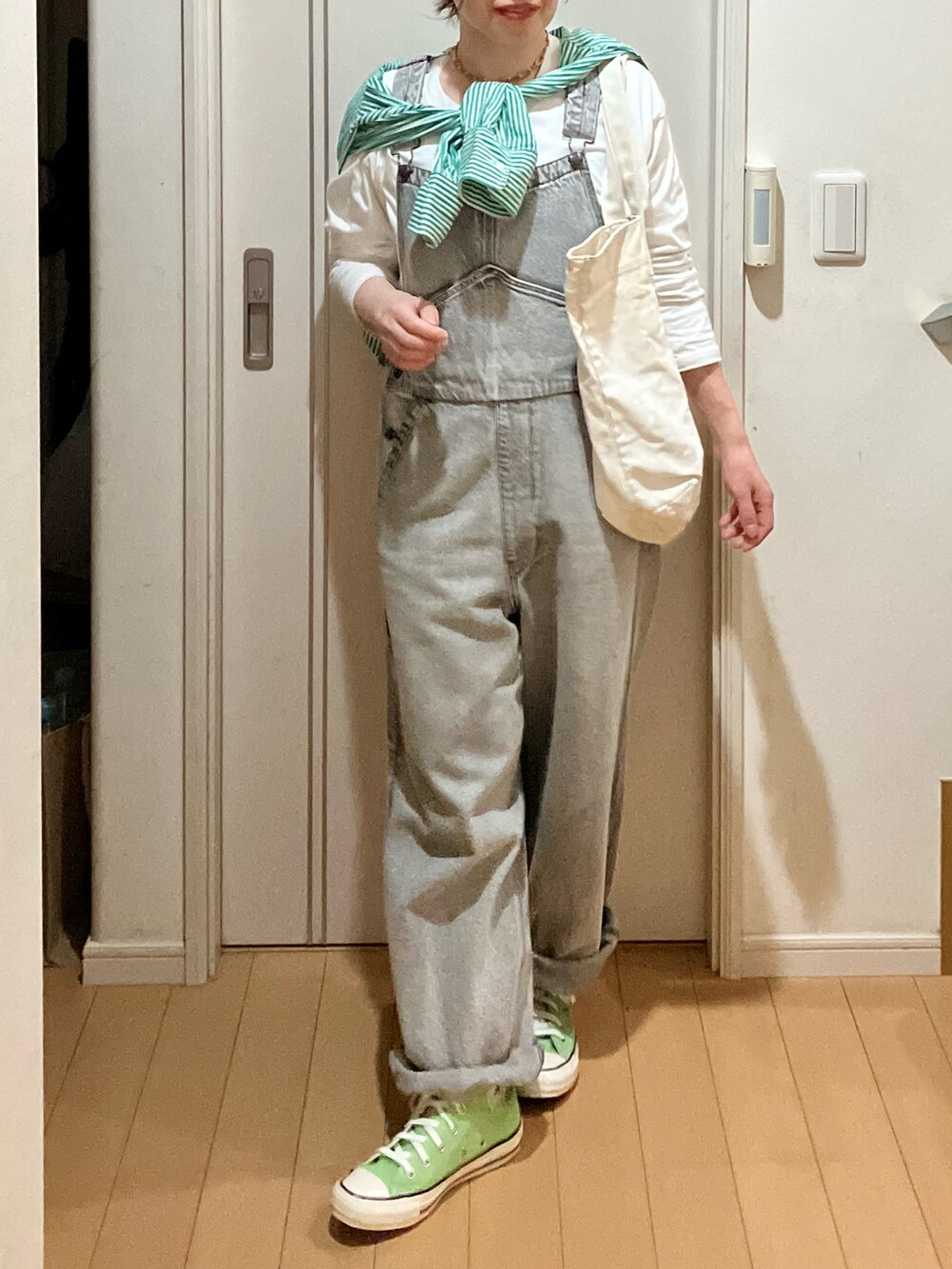 グレー系のサロペット/オーバーオール、グリーン系のシャツ/ブラウス、グリーン系のスニーカーを着用したレディースの春コーディネートの2枚目の写真