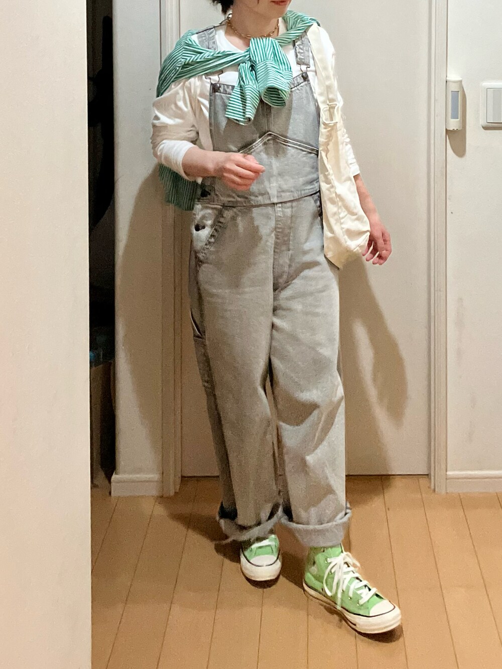 グレー系のサロペット/オーバーオール、グリーン系のシャツ/ブラウス、グリーン系のスニーカーを着用したレディースの春コーディネートの3枚目の写真