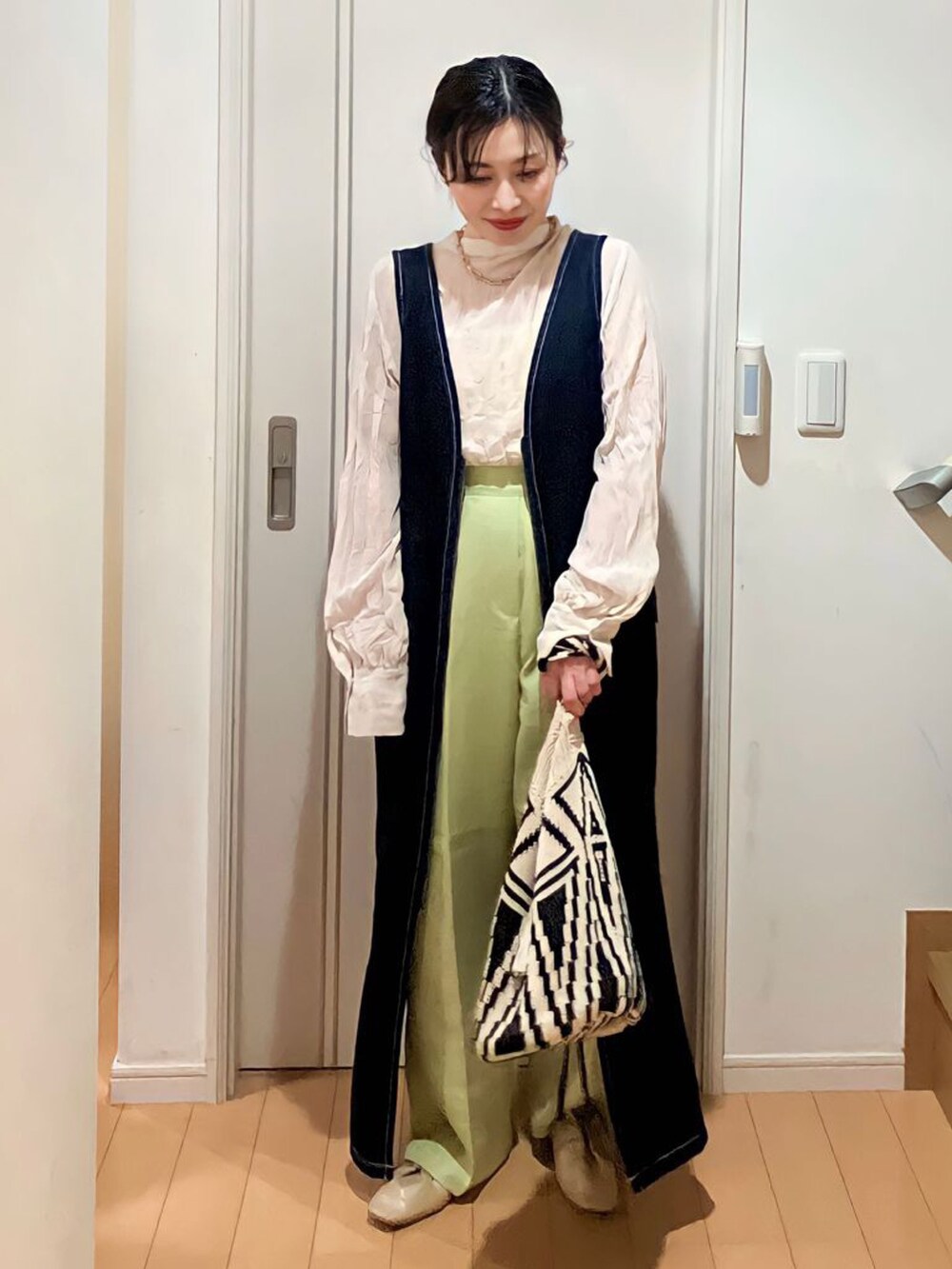 ベージュ系のシャツ/ブラウス、ブルー系のジャンパースカート、グリーン系のスラックスを着用したレディースの春コーディネートの2枚目の写真