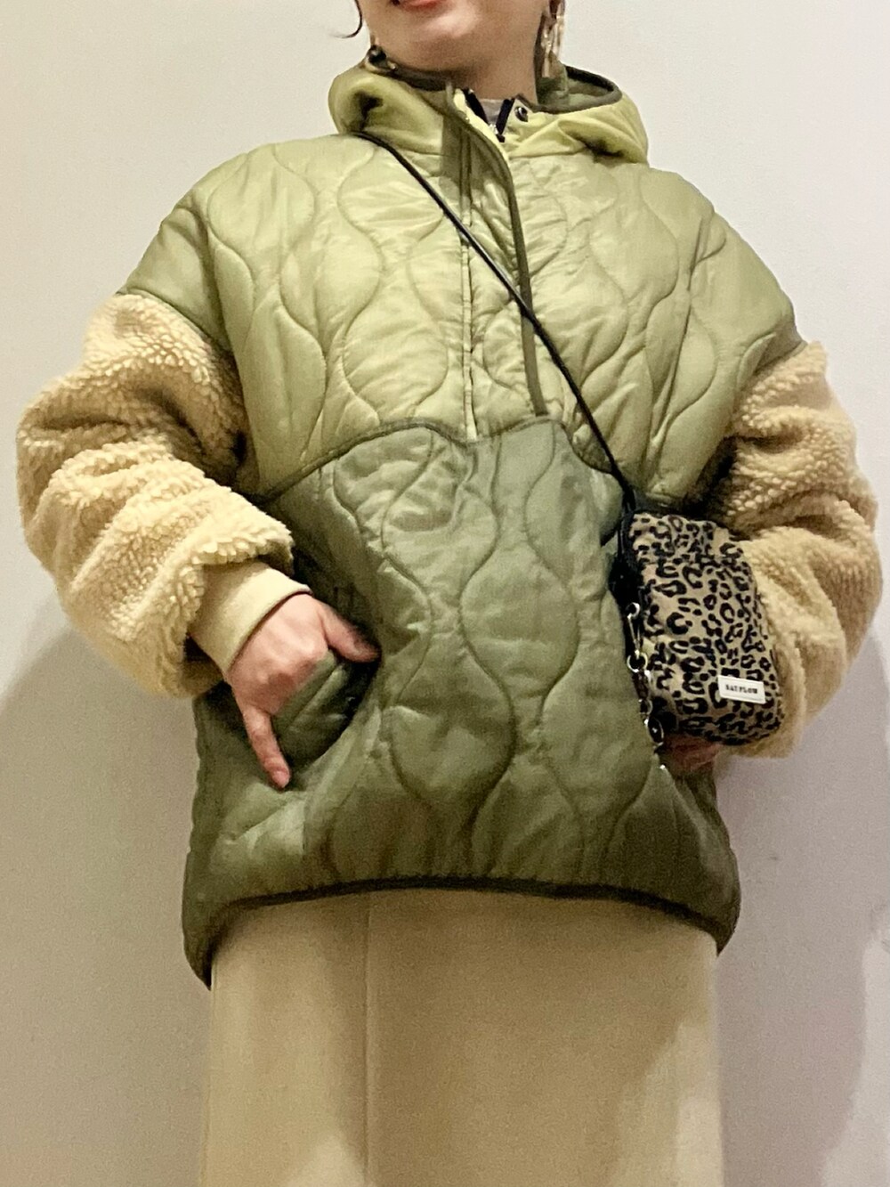 グリーン系のダウンジャケット/コート、ブラウン系のショルダーバッグ、ベージュ系のスカートを着用したレディースの冬コーディネートの2枚目の写真