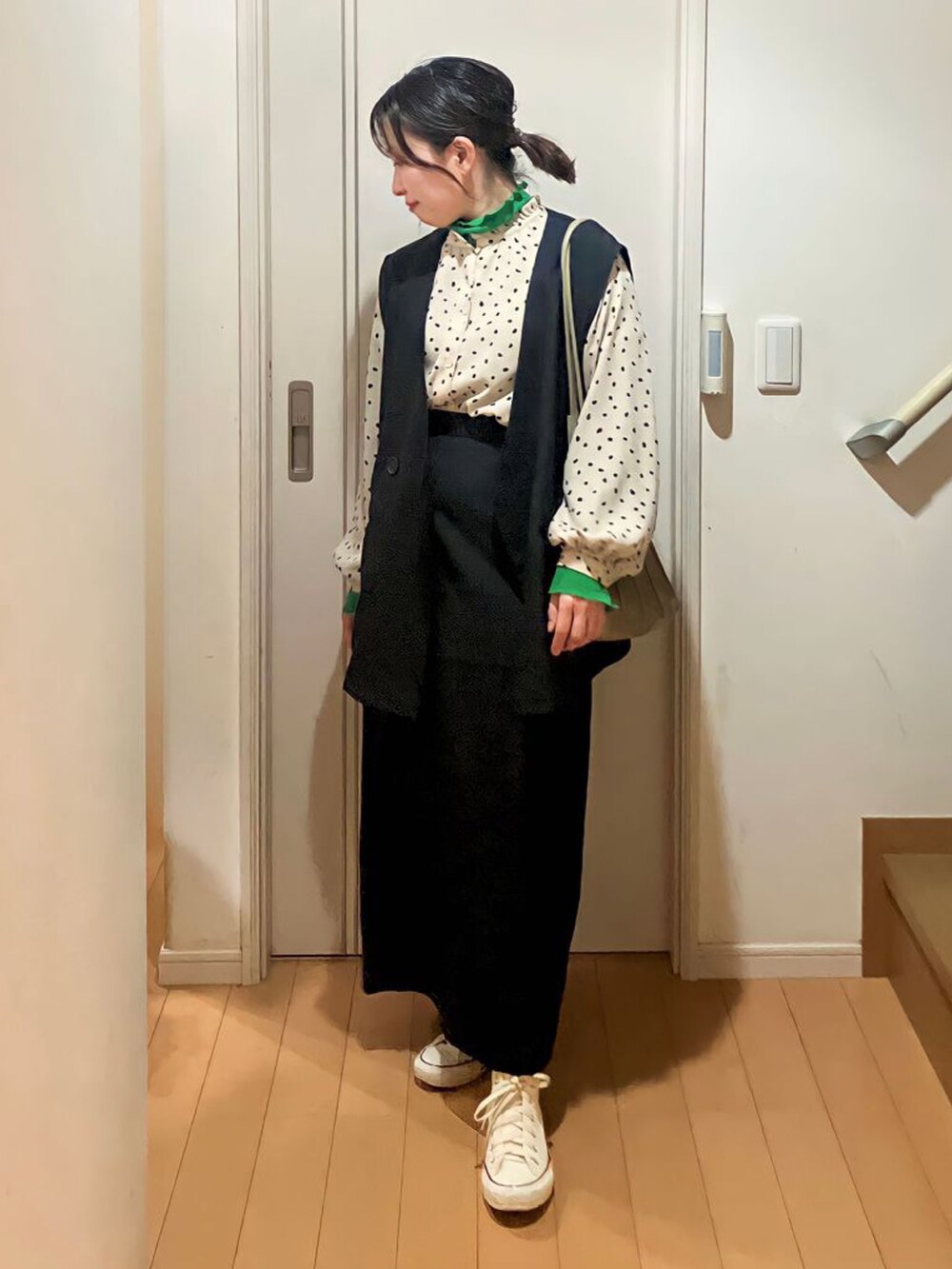 ブラック系のセットアップ、グリーン系のトップス、グリーン系のトートバッグを着用したレディースの春コーディネートの3枚目の写真