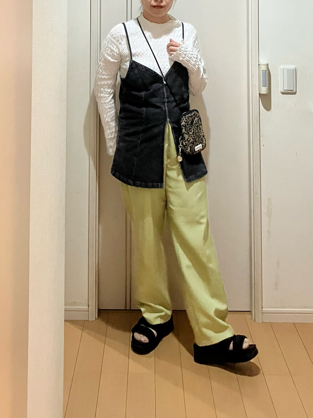 ブラック系のベスト、グリーン系のスラックス、ブラウン系のショルダーバッグを着用したレディースの秋コーディネートの3枚目の写真