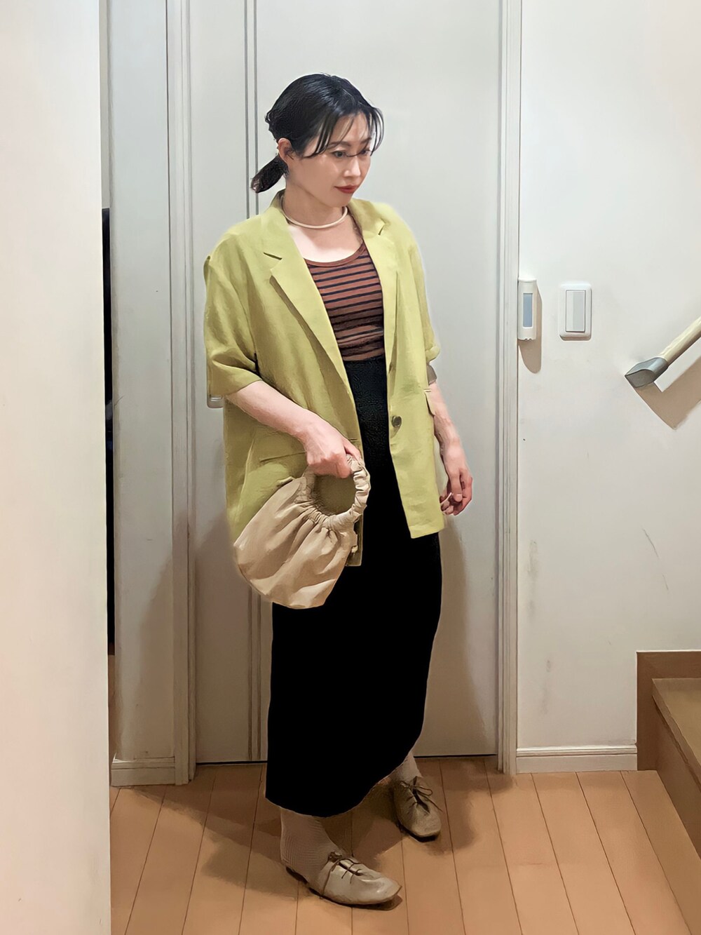 グリーン系のテーラードジャケット、ブラウン系のTシャツ/カットソー、ベージュ系のショルダーバッグを着用したレディースの春コーディネートの2枚目の写真