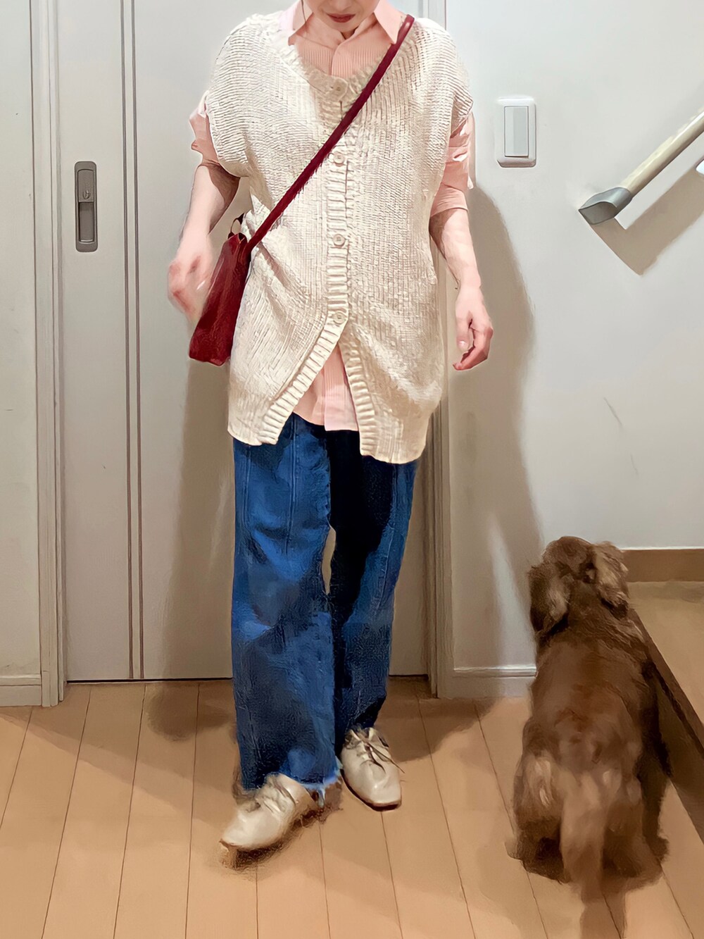 オレンジ系のシャツ/ブラウス、ベージュ系のベスト、ブルー系のデニムパンツを着用したレディースの春コーディネートの3枚目の写真