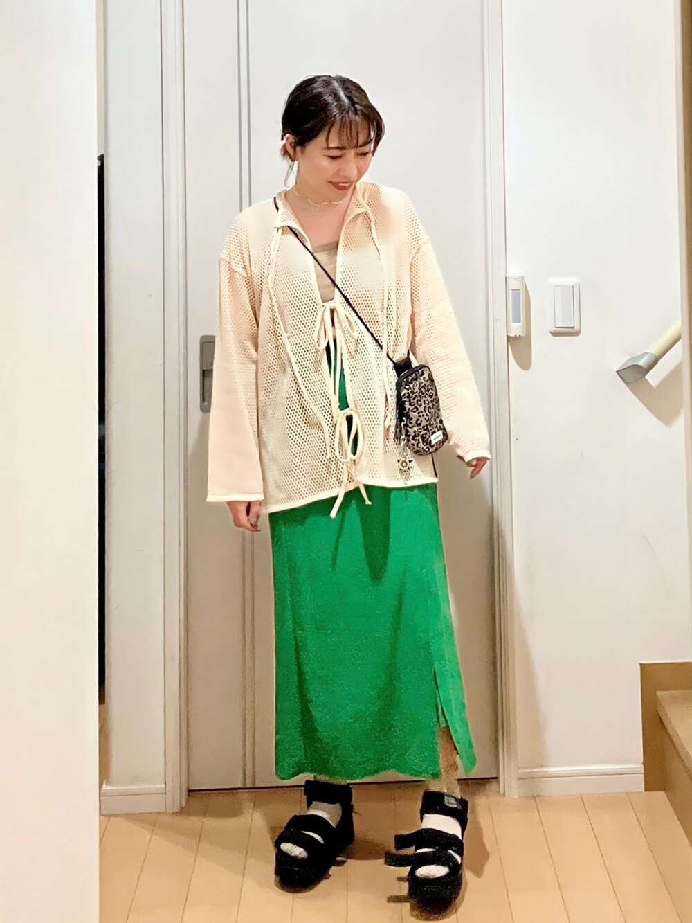 ホワイト系のカーディガン/ボレロ、ブラウン系のショルダーバッグ、グリーン系のスカートを着用したレディースの夏コーディネートの2枚目の写真