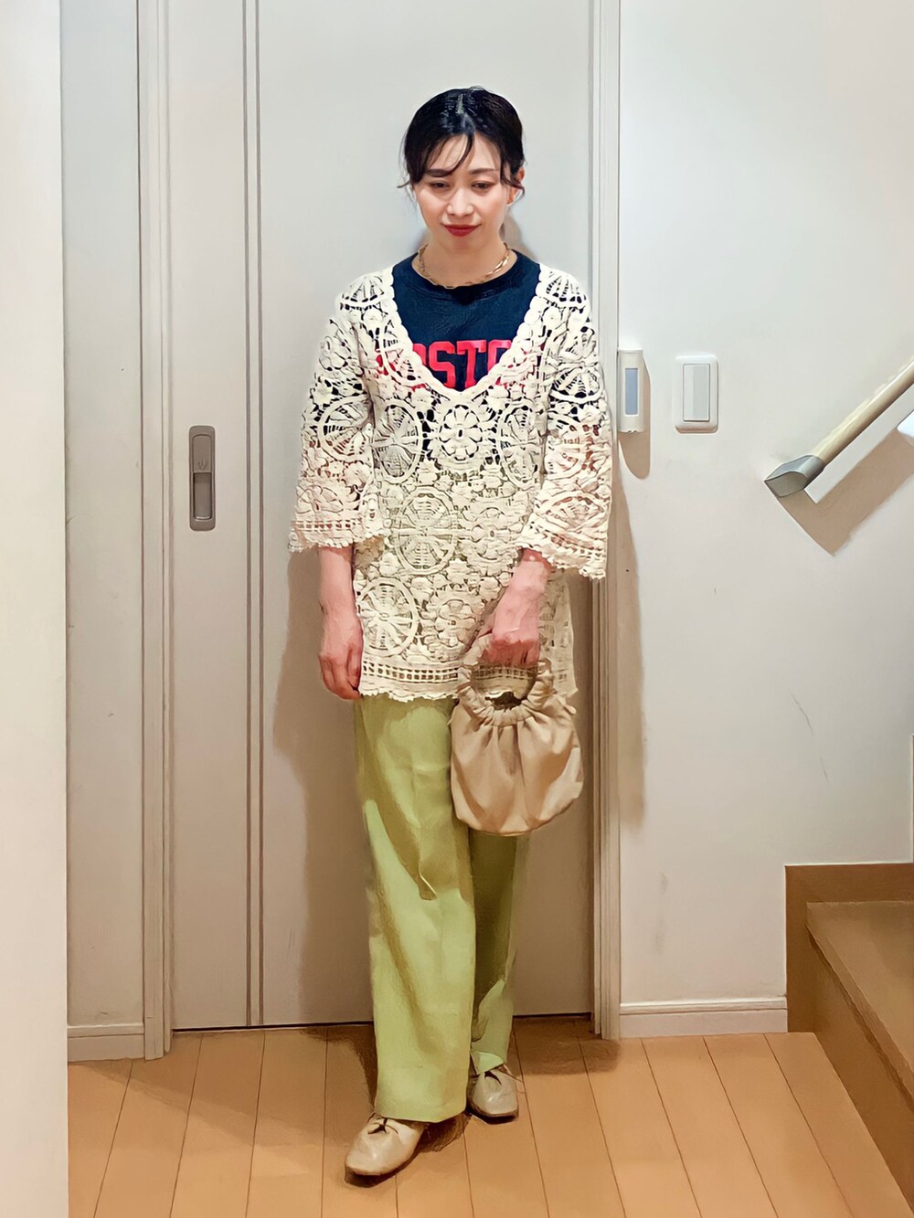 ホワイト系のニット/セーター、ブルー系のTシャツ/カットソー、ベージュ系のショルダーバッグを着用したレディースの春コーディネートの2枚目の写真