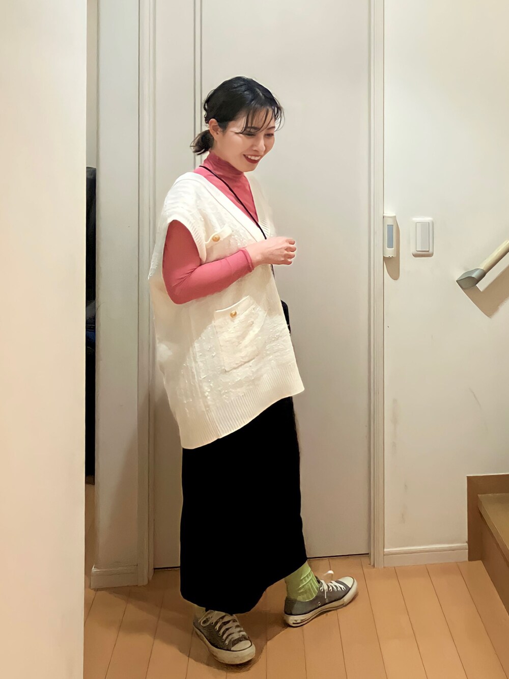 ピンク系のTシャツ/カットソー、ホワイト系のベスト、ブラック系のスカートを着用したレディースの春コーディネートの2枚目の写真