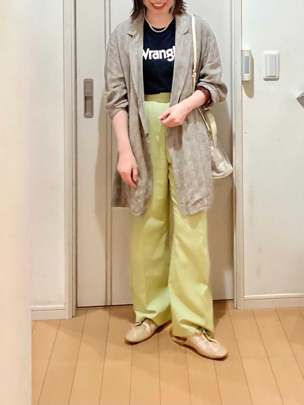 ブラウン系のテーラードジャケット、グリーン系のスラックス、ベージュ系のサンダルを着用したレディースの夏コーディネートの2枚目の写真