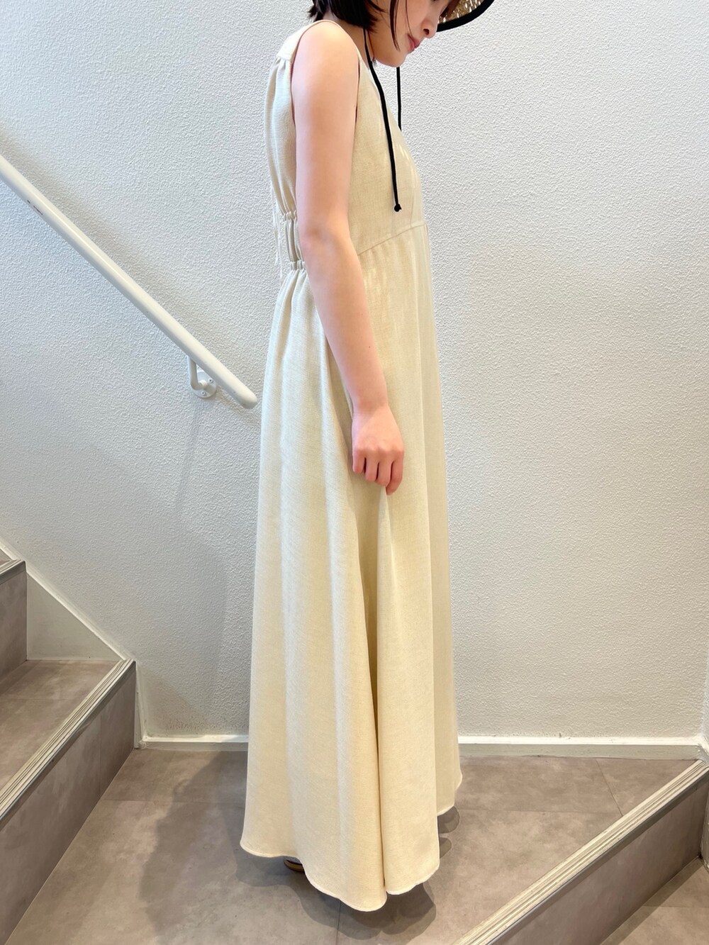 ベージュ系のワンピース、ブルー系のデニムパンツ、ベージュ系のサンダルを着用したレディースの夏コーディネートの4枚目の写真