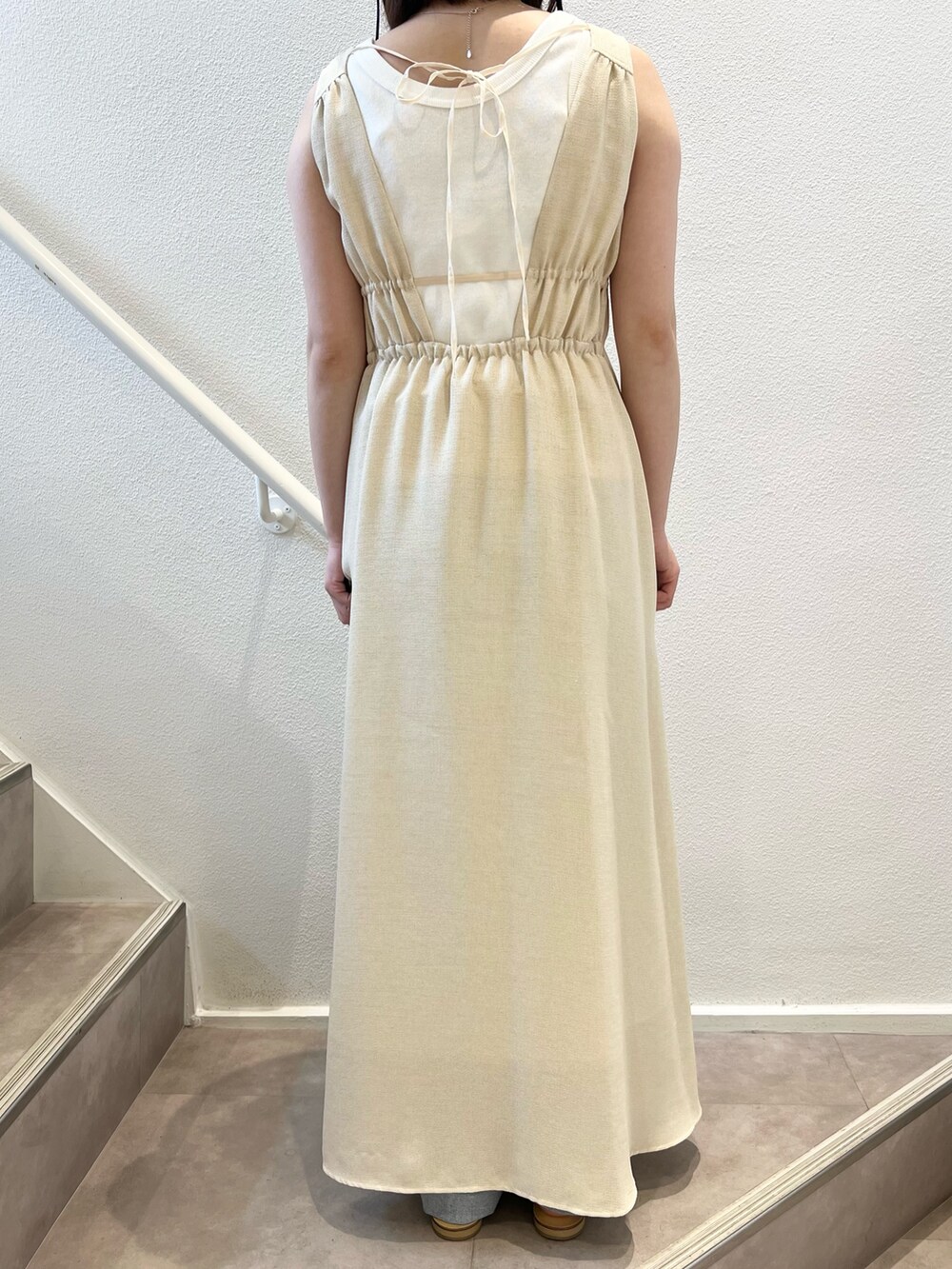 ベージュ系のワンピース、ブルー系のデニムパンツ、ベージュ系のサンダルを着用したレディースの夏コーディネートの5枚目の写真