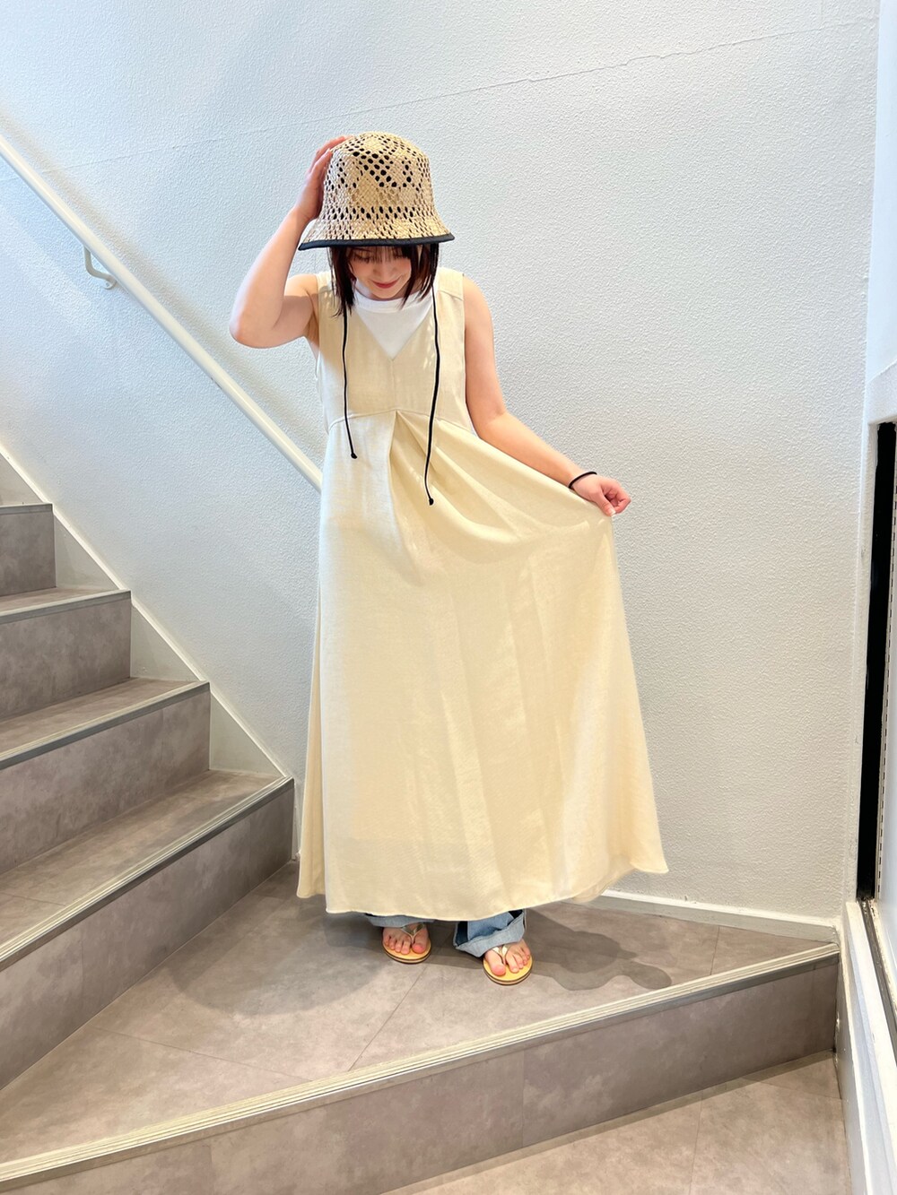 ベージュ系のワンピース、ブルー系のデニムパンツ、ベージュ系のサンダルを着用したレディースの夏コーディネートの3枚目の写真