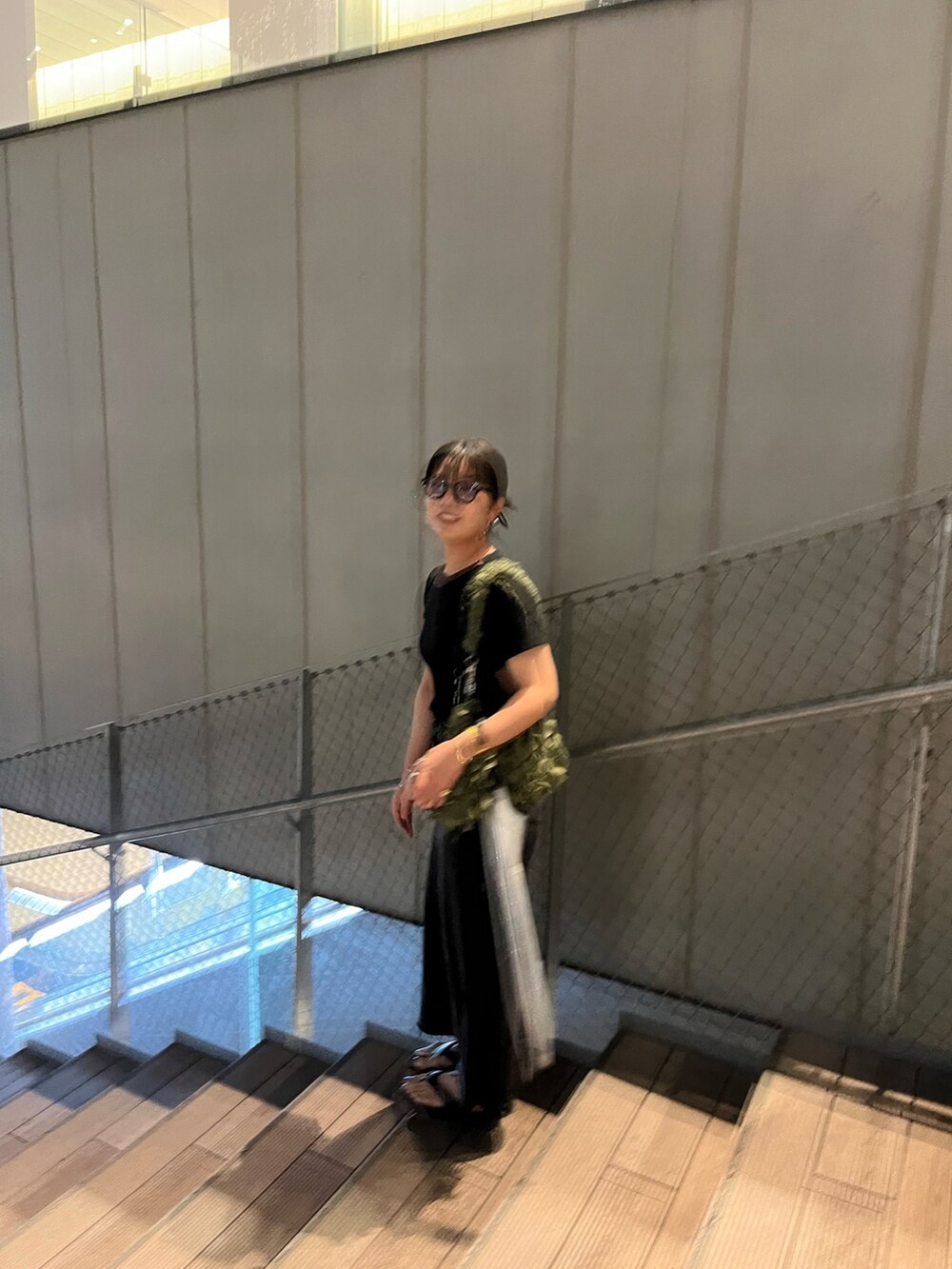 ブラック系のTシャツ/カットソー、グリーン系のショルダーバッグ、ブラック系のデニムスカートを着用したレディースの冬コーディネートの2枚目の写真