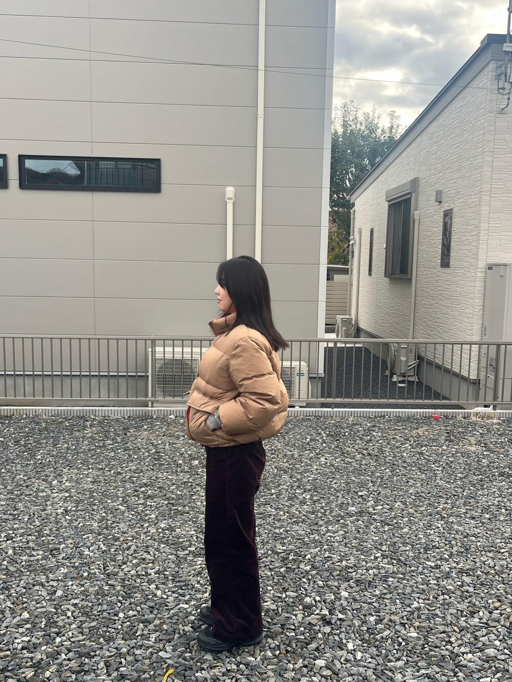 ベージュ系のダウンジャケット/コート、グリーン系のスウェット、レッド系のその他パンツを着用したレディースの冬コーディネートの3枚目の写真