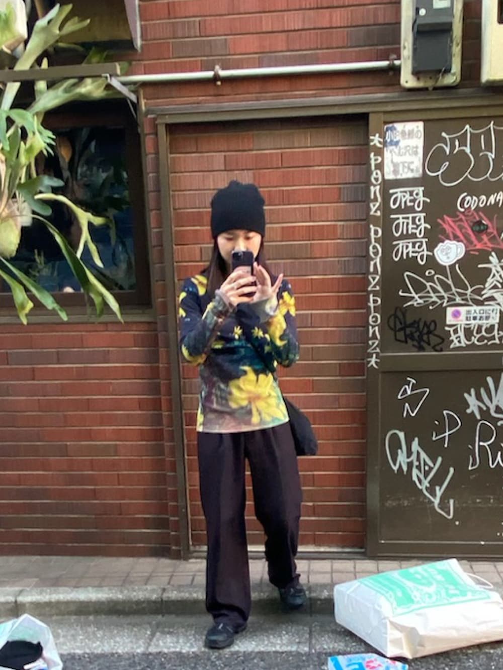 イエロー系のシャツ/ブラウス、ブラック系のスラックス、ブラック系のスニーカーを着用したレディースの冬コーディネートの2枚目の写真